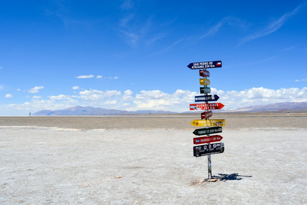 Sign Post in the desert with multiple signs on it.